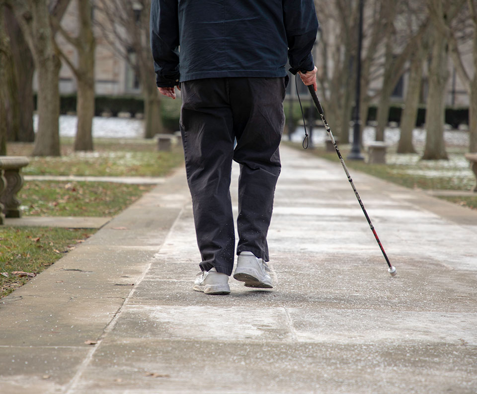 Pedestrian with visual impairment walking around Oakland in Pittsburgh.