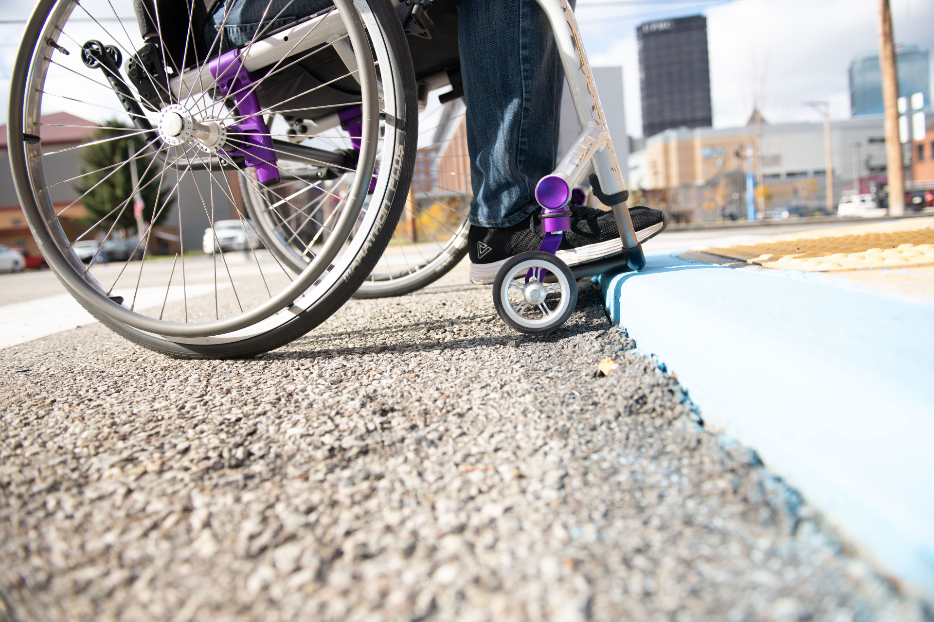 Image of a wheelchair user struggling to navigate a curb ramp that has a major level change